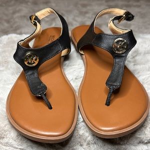 Black and tan Michael Kors flat sandals with gold Michael Kors Logo. Size 7.5